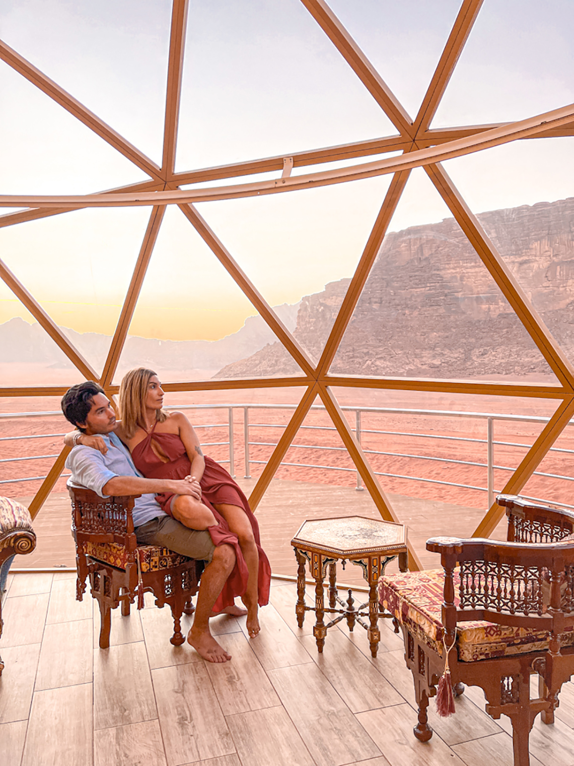 noi due seduti nella camera con vetrate dentro il deserto
