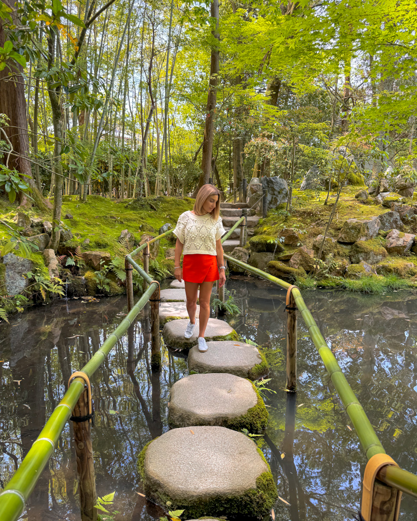Ragazza che cammina su una passerella di tronchi su un laghetto al Tenjyuan garden