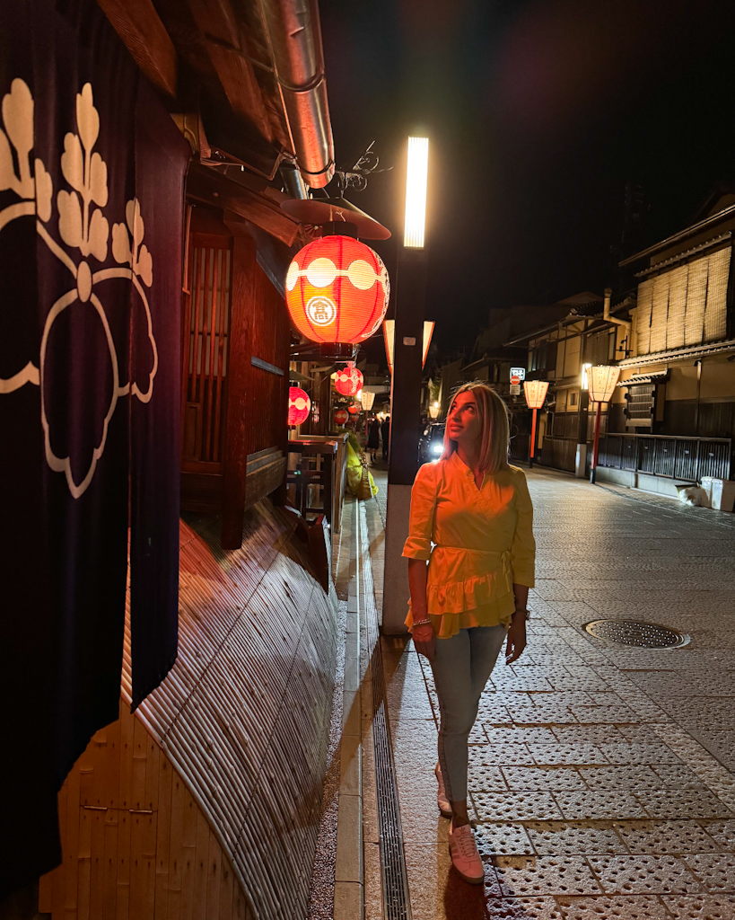 Ragazza sotto una lanterna illuminata di rosso nel quartiere di Gion a kyoto
