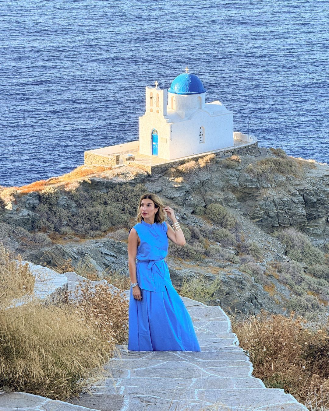 Chiesa a picco sul mare con me in sfondo a Sifnos nelle Cicladi in Grecia