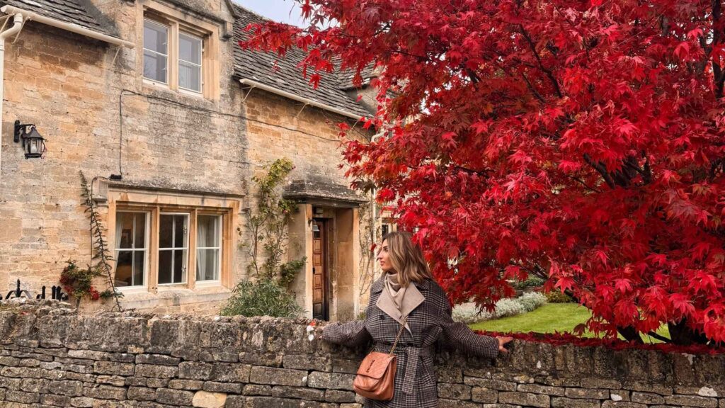 Villaggio delle Cotswolds con albero rosso in autunno